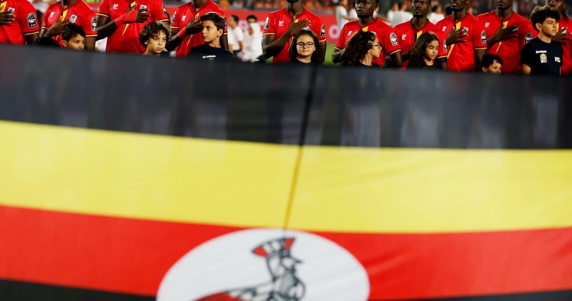 Ugandan players standing with national flag before match