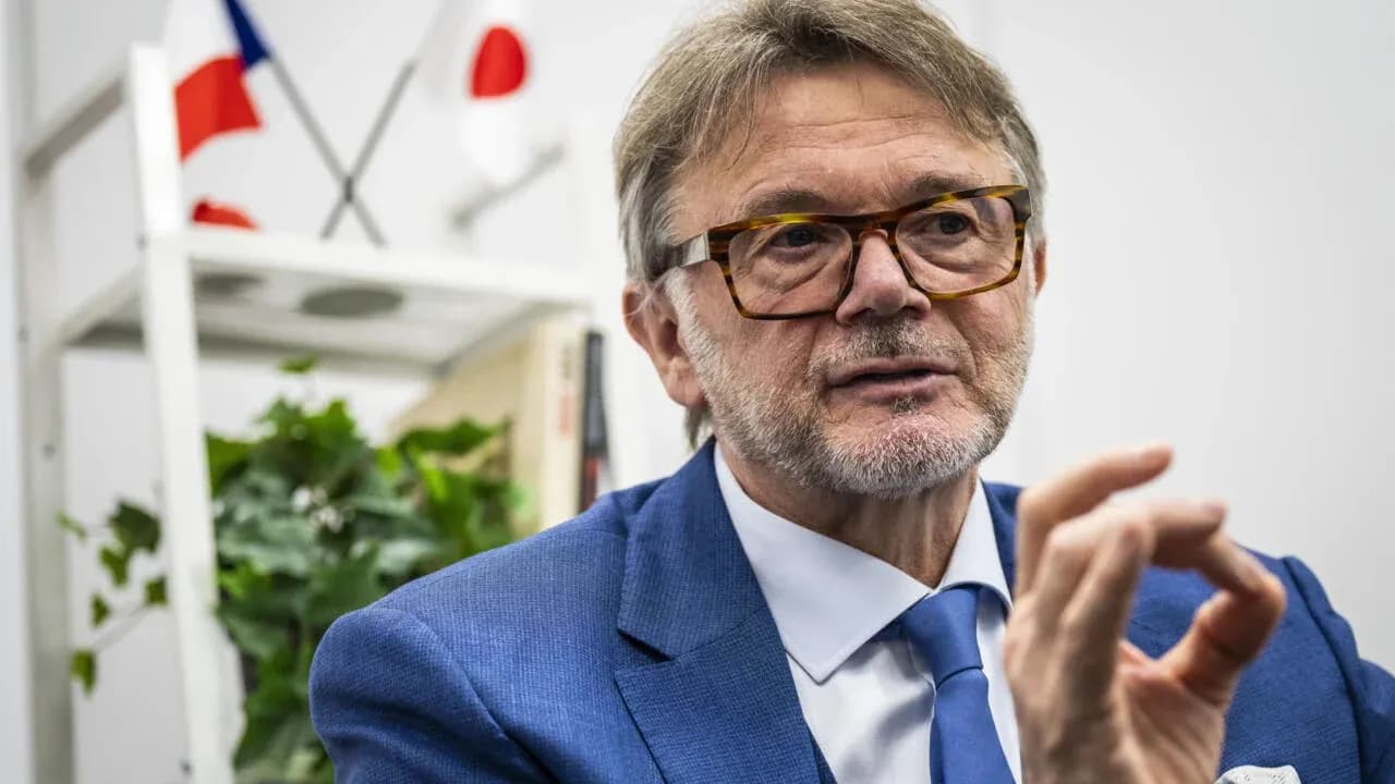 Man in blue suit speaking with hand gesture