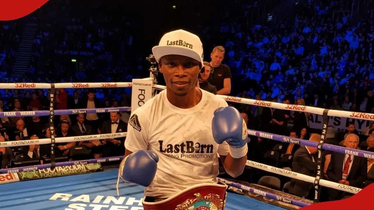 Boxer posing with championship belt in ring