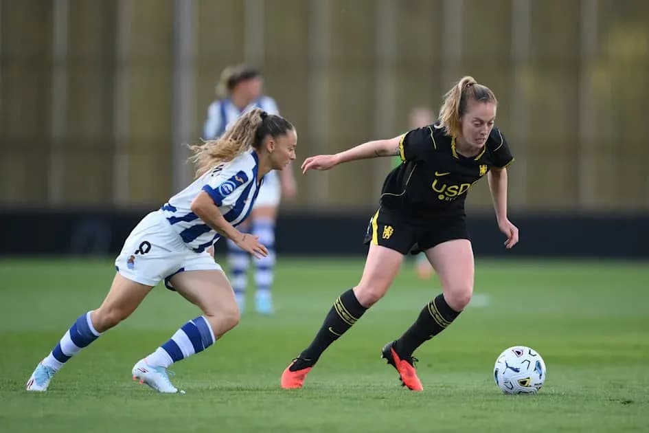 Two female players competing for the ball