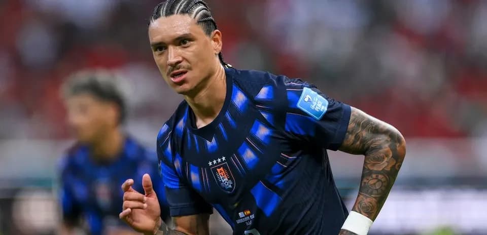 Futbolchi maydonda harakatda, jamoasi kiyimida