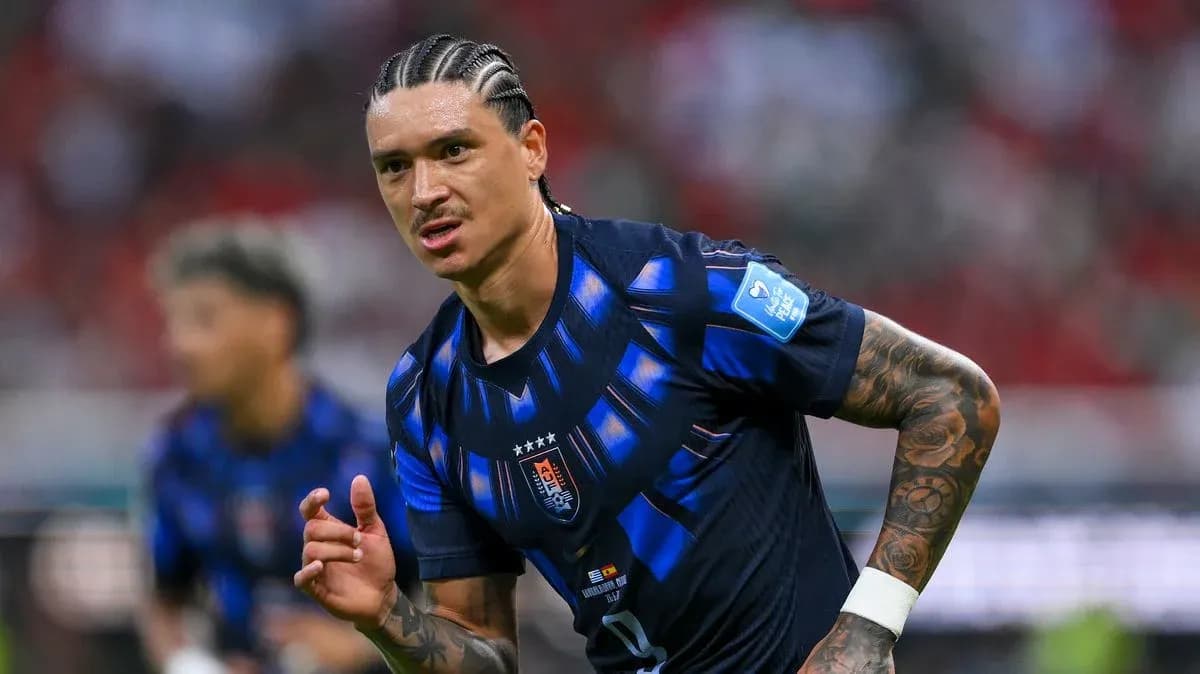 Futbolchi maydonda harakatda, jamoasi kiyimida