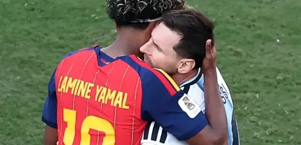 Lamine Yamal and Lionel Messi embracing on field