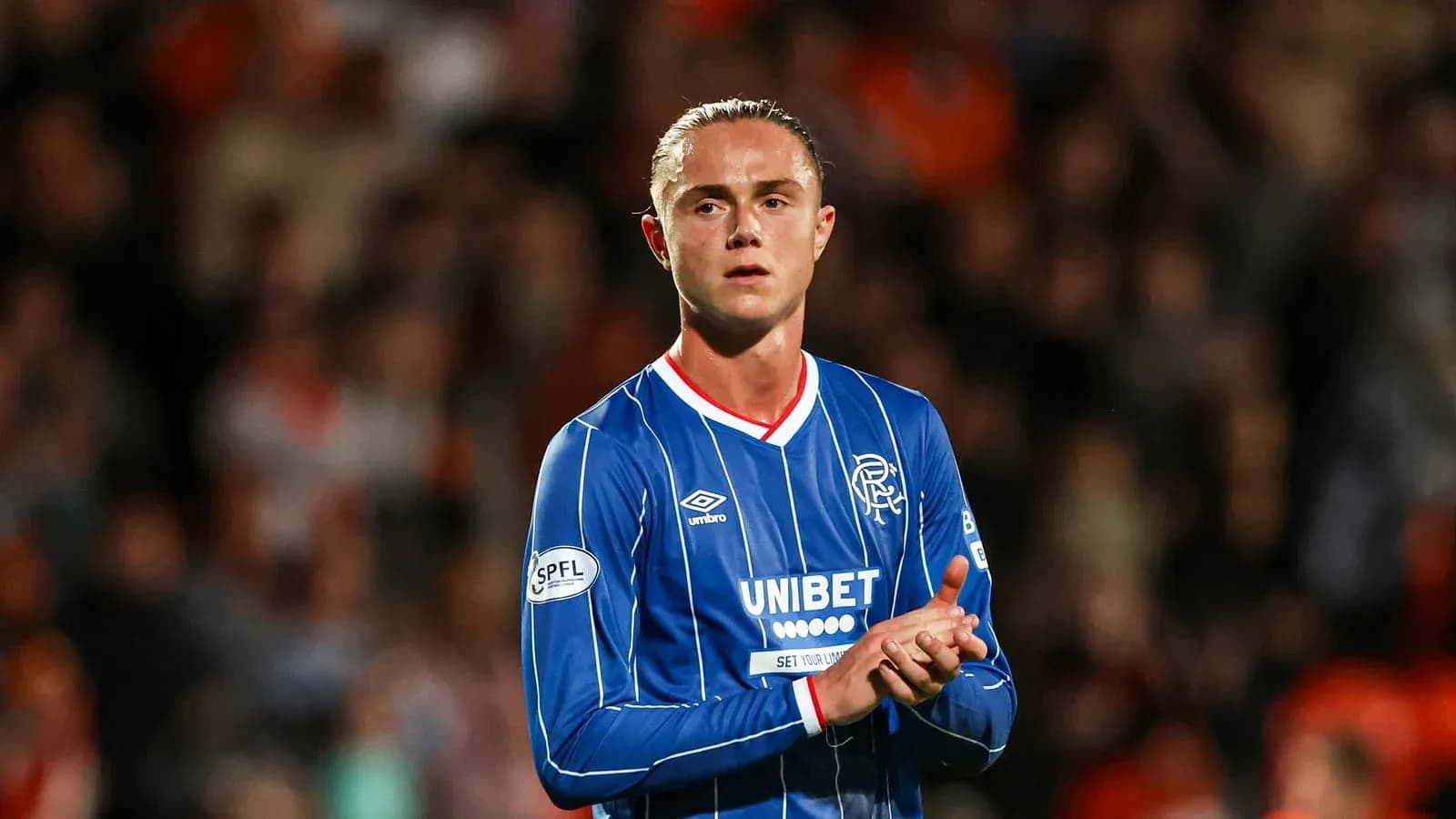 Futbolchi Rangers formasida maydonda qizil va ko'k