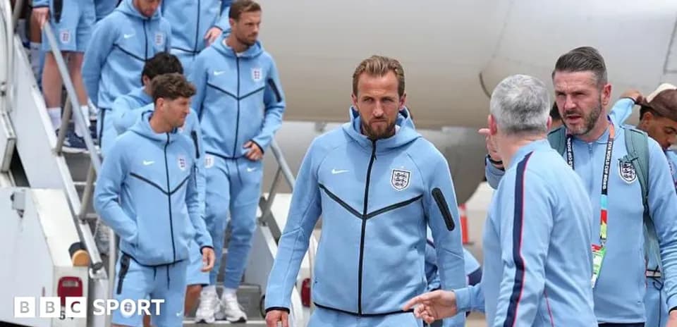 England team disembarking from airplane in blue tracksuits