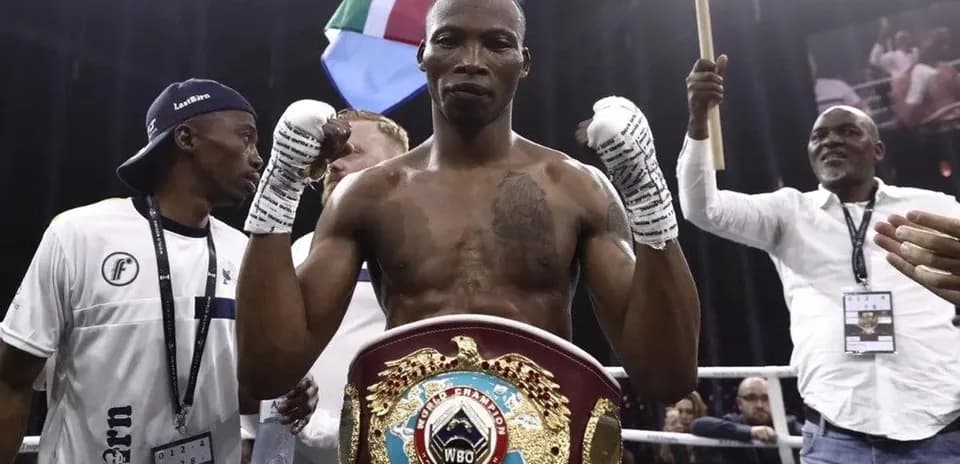 Boxer celebrating with championship belt in ring
