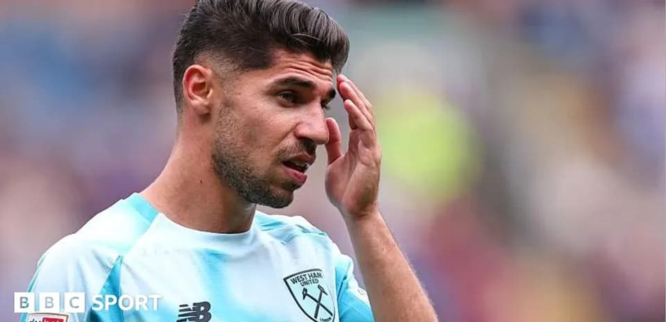Futbolchi West Ham United formasida, qo'lida boshiga tegmoqda