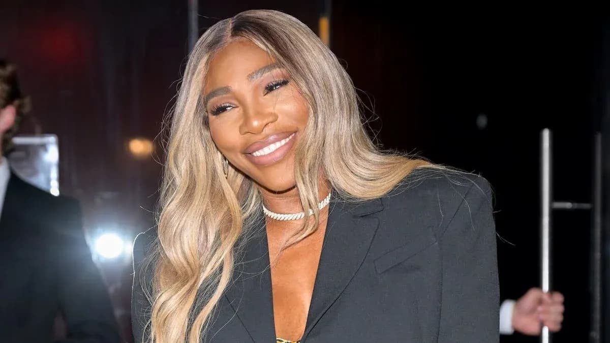 Woman smiling in stylish black outfit at event