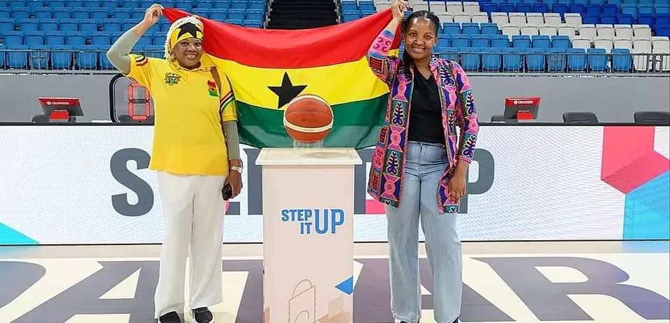 Two women holding Ghana flag with basketball