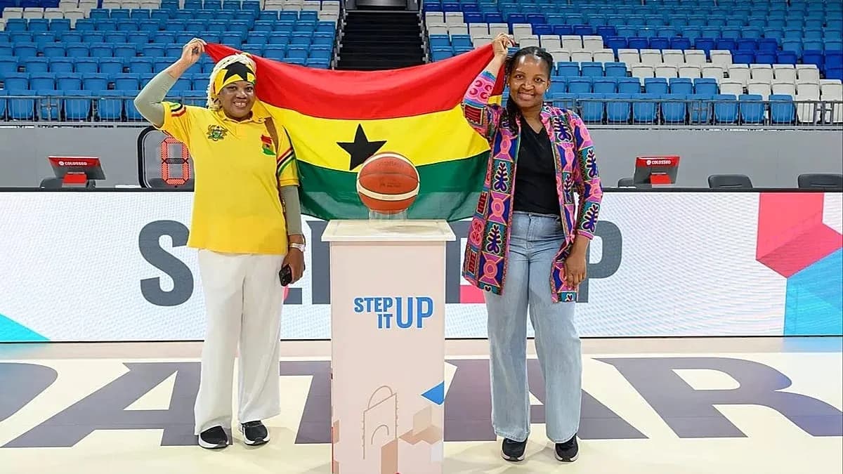Two women holding Ghana flag with basketball