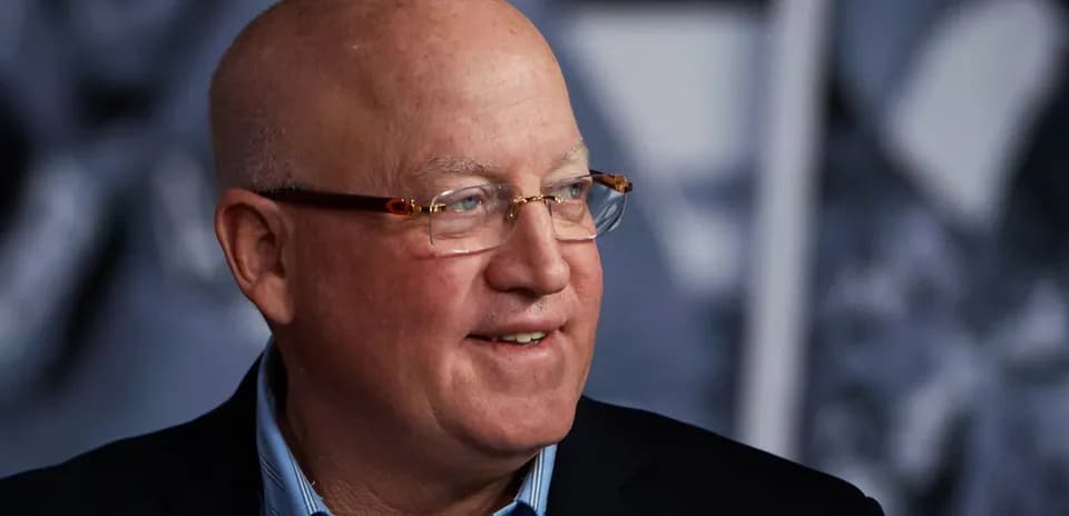 Shirt-clad man smiling during an event