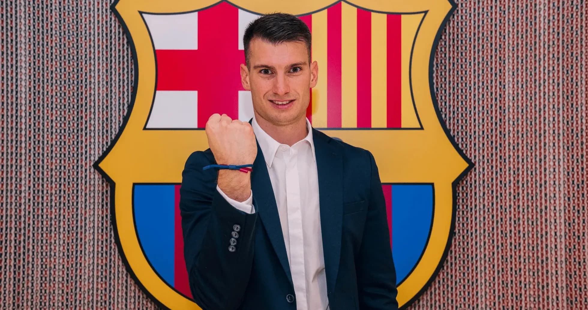 Yoshinori Muto standing in front of FC Barcelona logo