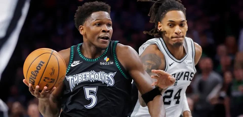 Player dribbling basketball with defender close behind
