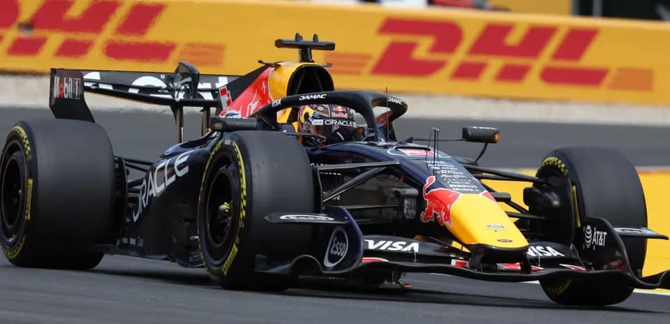 Formula 1 car racing on track with DHL banner
