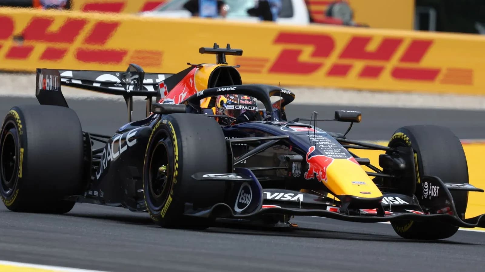 Formula 1 car racing on track with DHL banner