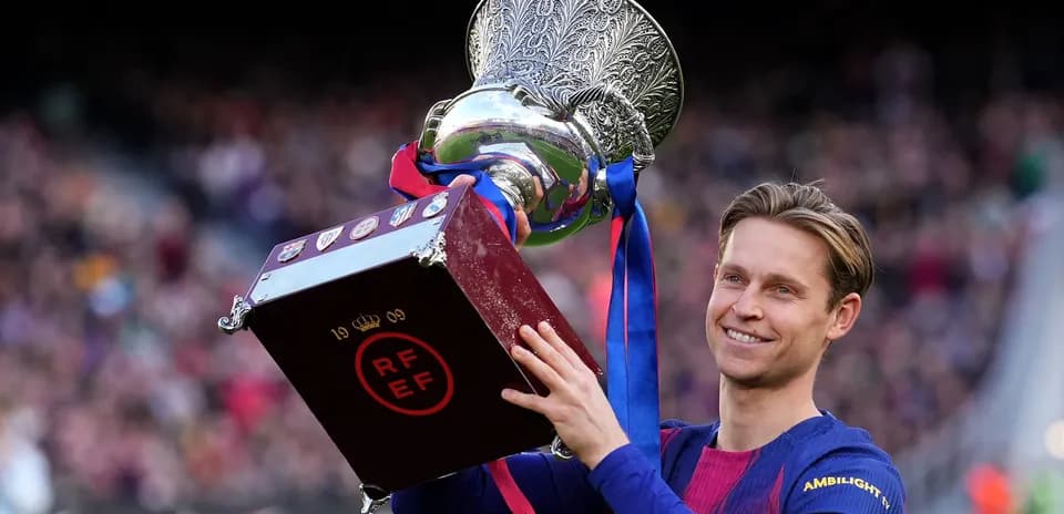 Frenkie de Jong holding trophy after match victory