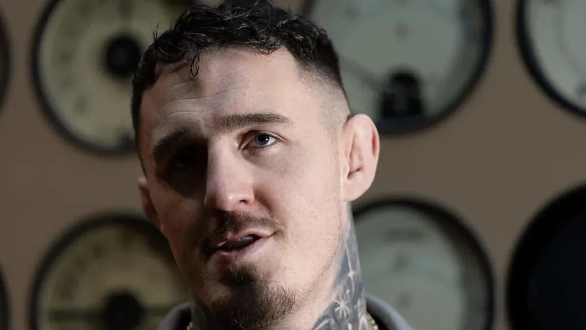 Man with tattoos speaking in front of gauges