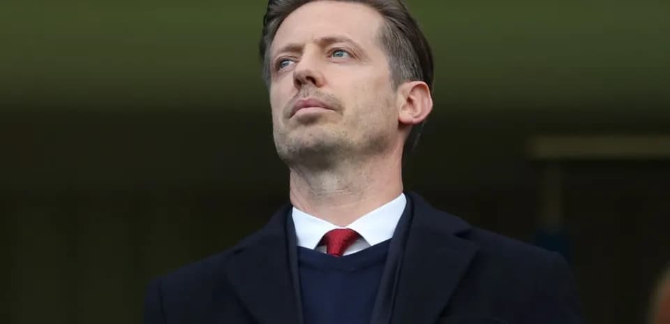 Man in formal attire observing from the stands
