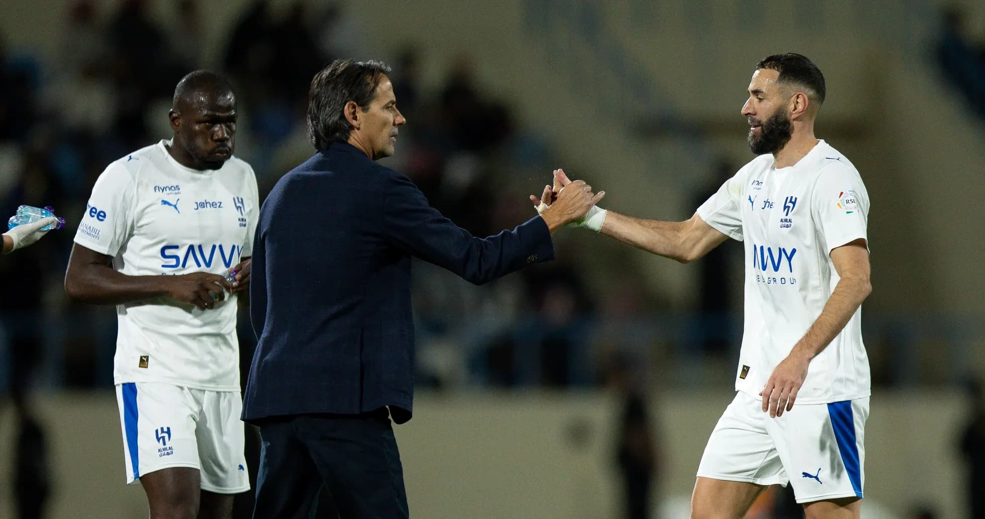 Trener futbolchilar bilan qo'l siqishmoqda