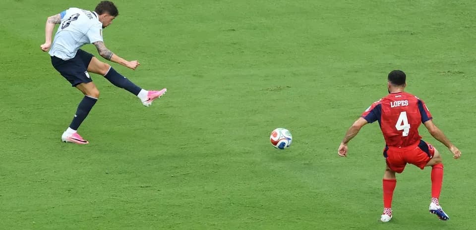 Player kicking ball while opponent defends during match