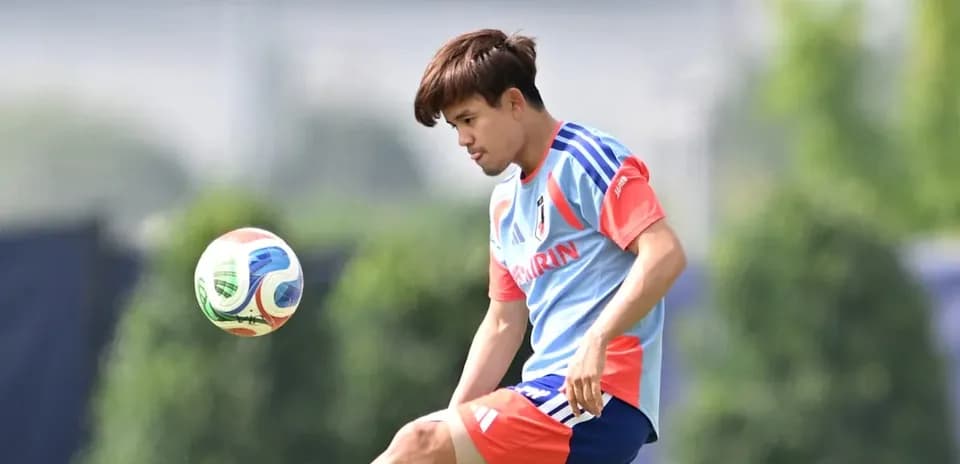 Futbolchi to'pni ushlab turib, mashg'ulotda