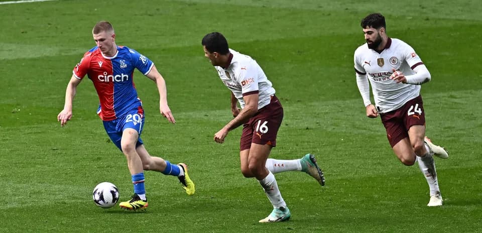 Crystal Palace player evading two defenders during match