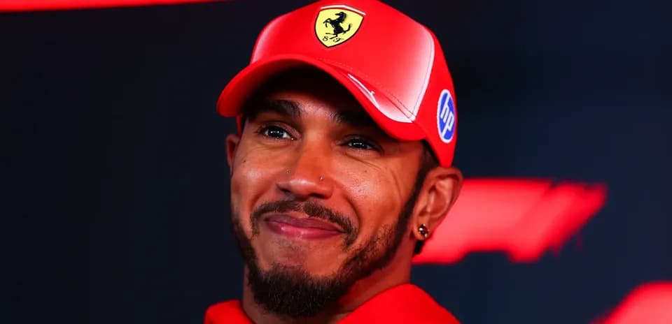 Lewis Hamilton smiling in red Ferrari cap