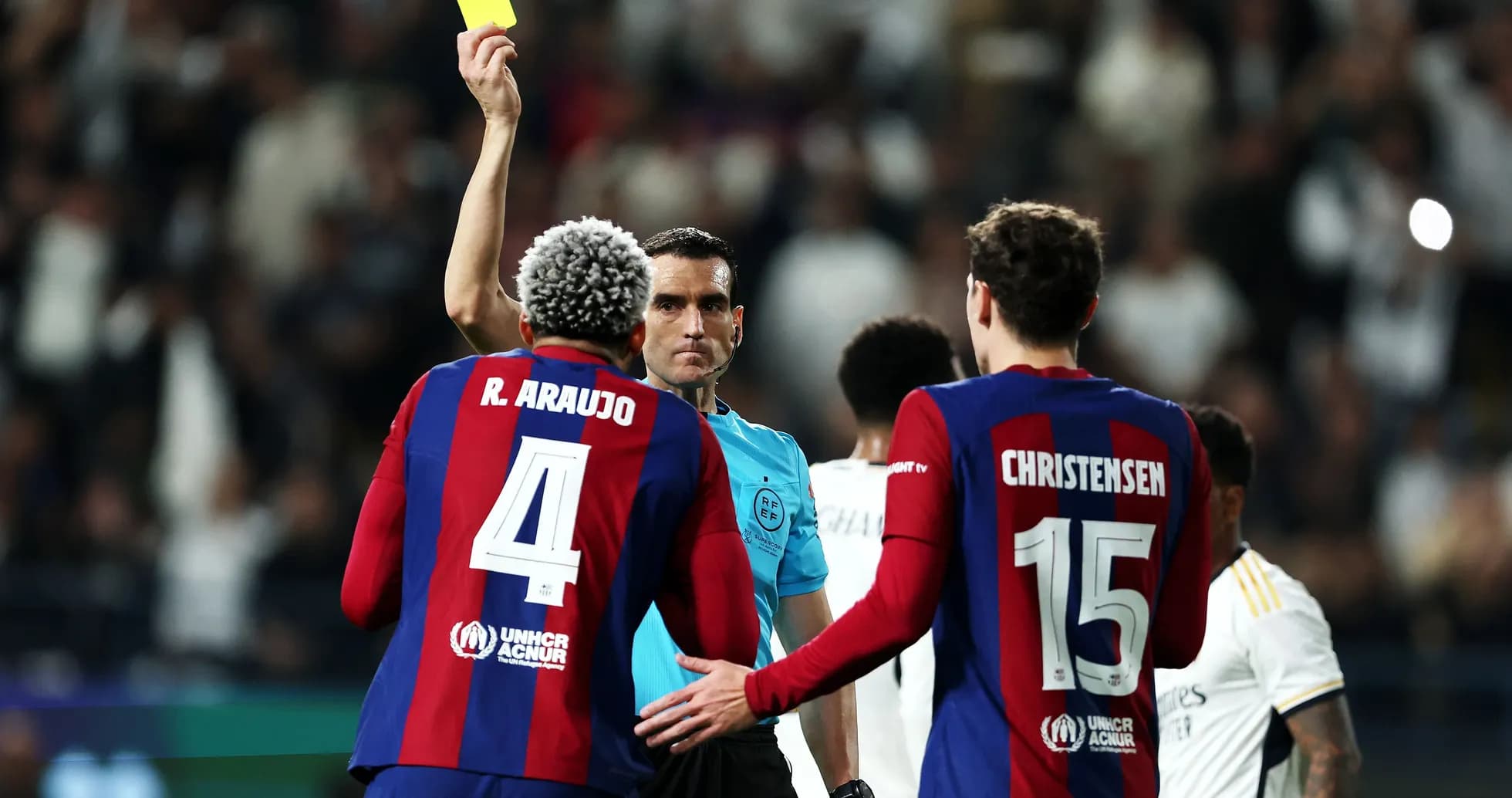 Referee showing yellow card to player during match