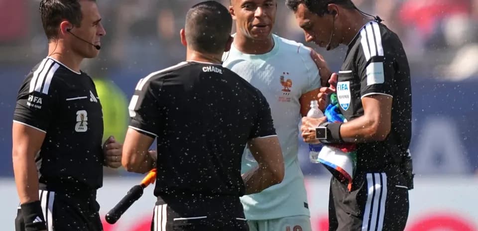 Futbol hakamlari va o'yinchi muhokama qilmoqda