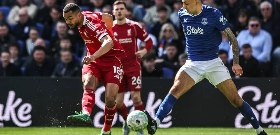 Liverpool and Everton players competing for the ball