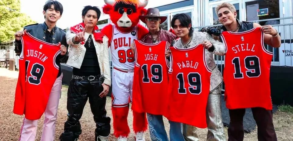 Group posing with basketball jerseys and mascot