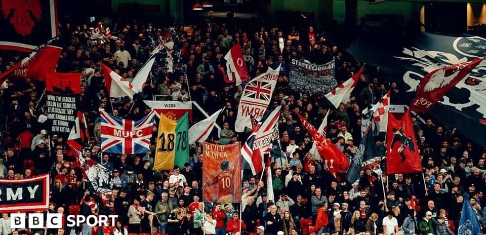 Football fans waving flags in stadium stands