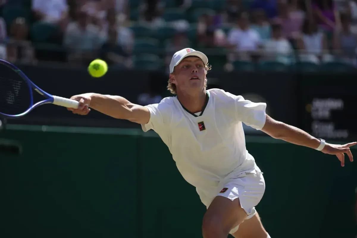 Tennis player reaching for a flying ball