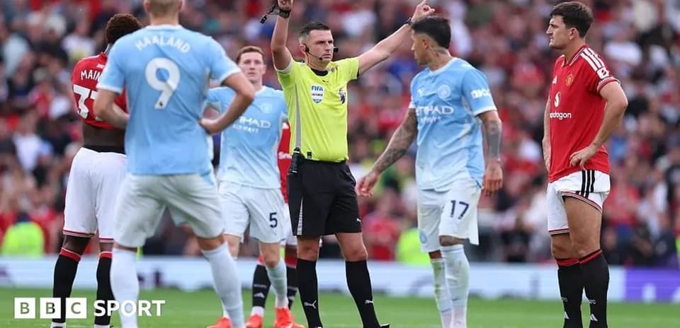 Referee signaling during Manchester derby match