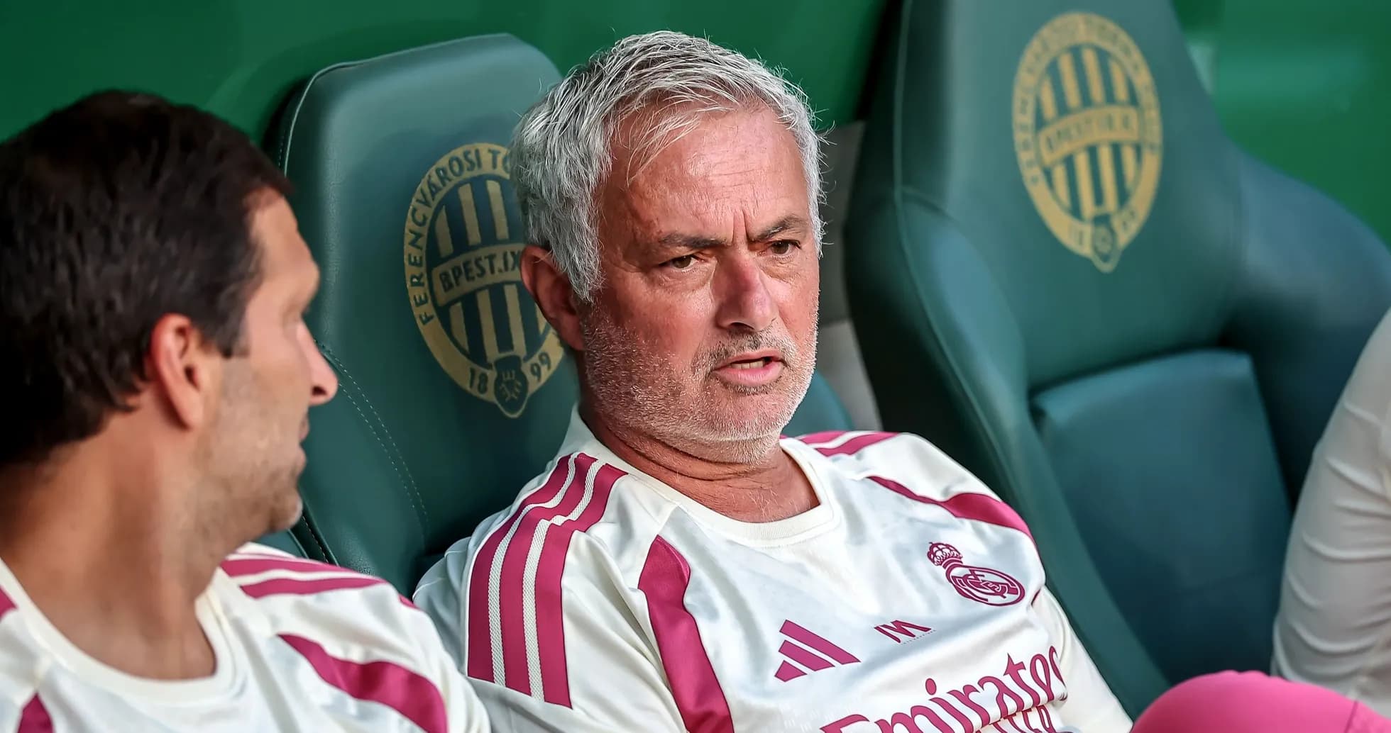 Men sitting on bench during football match