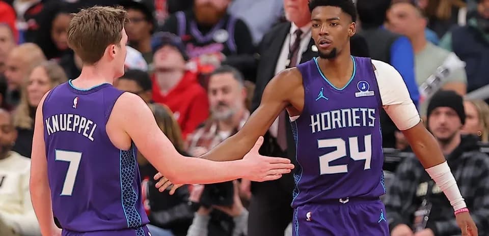 Hornets players greeting each other during game