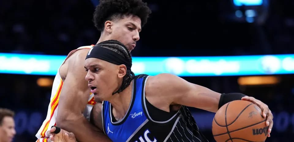 Two basketball players competing for possession of the ball