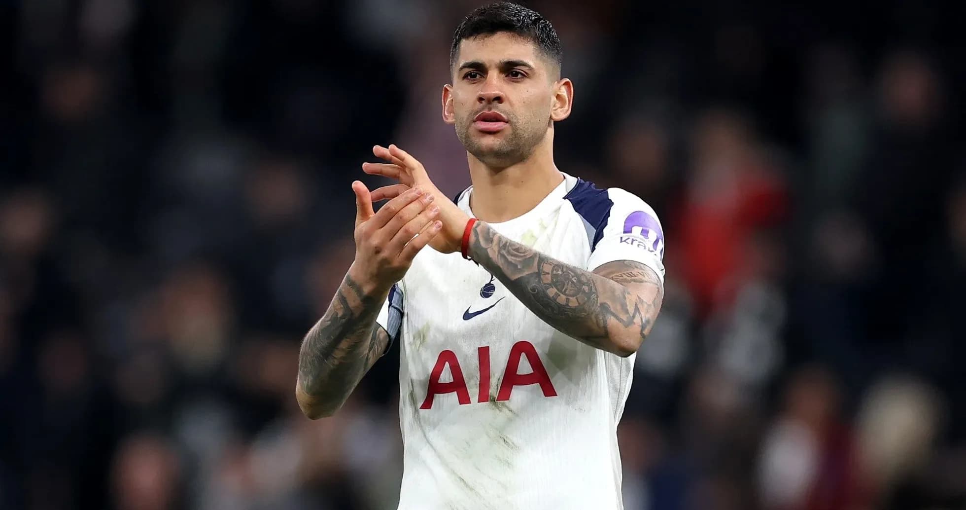 Futbolchi qizil AIA ko'ylakda qo'llarini qarsak chalmoqda