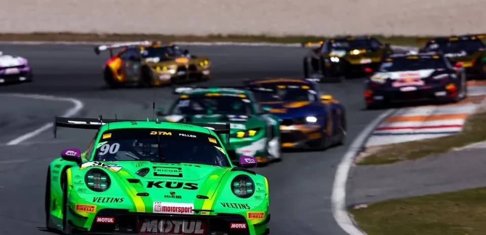 Green race car leading a group on the track