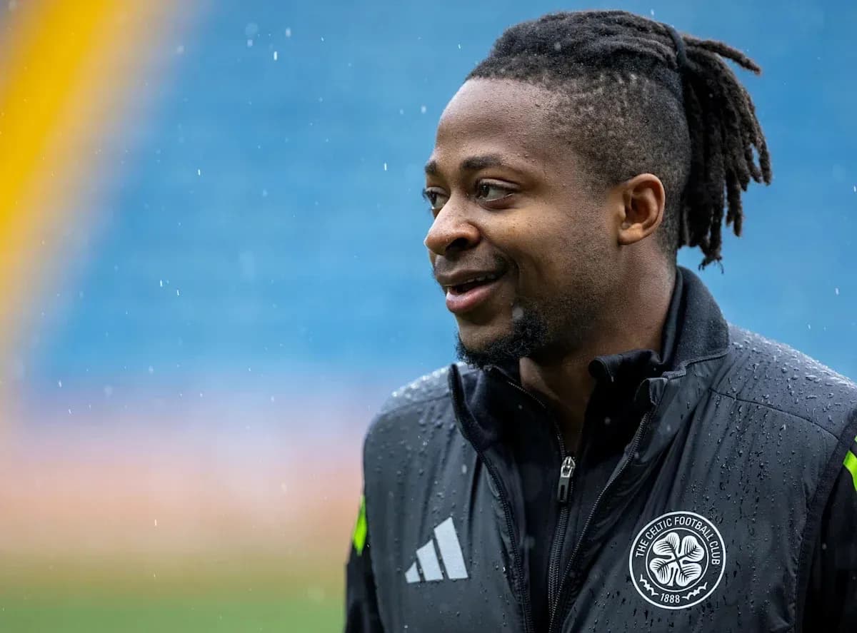 Futbolchi maydonda, yomg'irda kulayotgan holatda