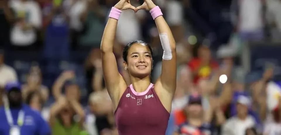 Tennis player celebrating with heart gesture after match