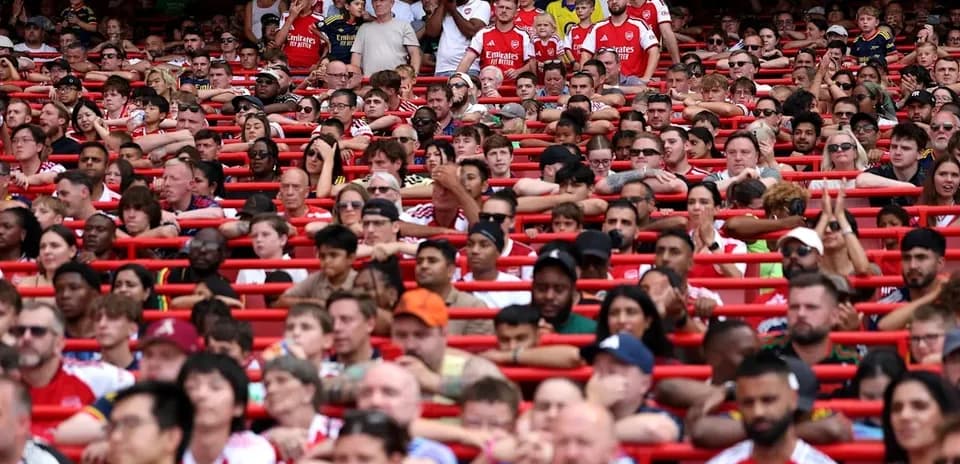 Arsenal fans seated in stadium stands during match