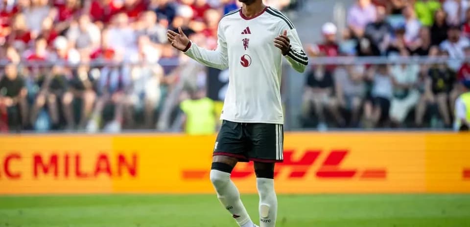Futbolchi maydonda qo'llarini ochib turibdi