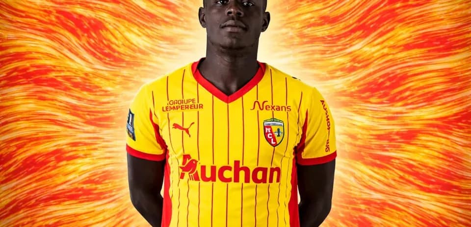 Futbolchi jamoasi formasi bilan turgan futbolchi