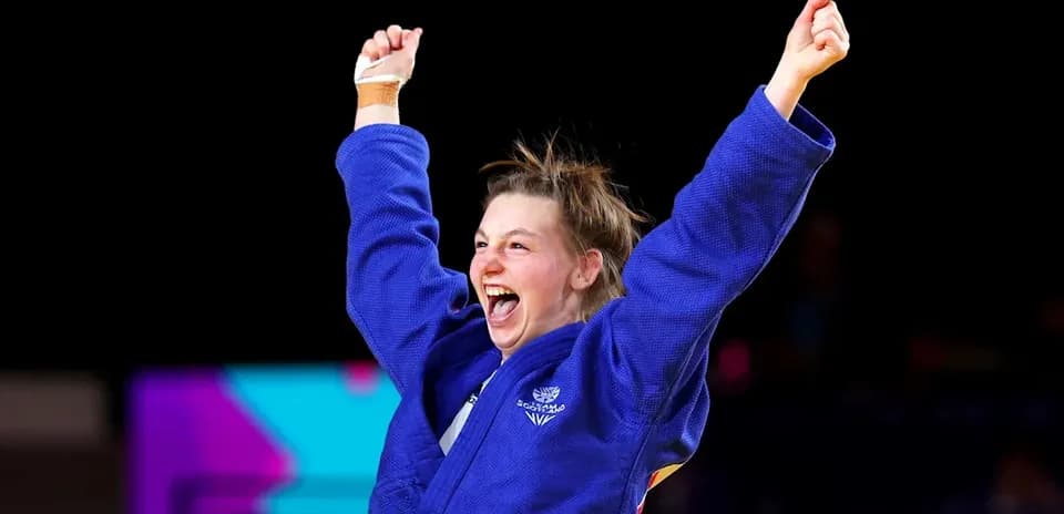 Judo athlete celebrating victory with raised arms