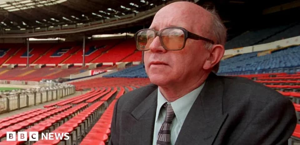 Man in glasses sitting in empty stadium seats