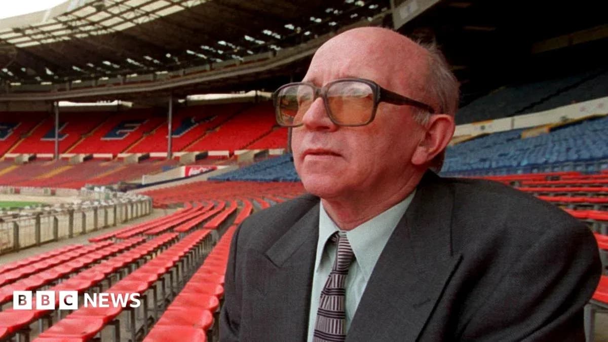Man in glasses sitting in empty stadium seats