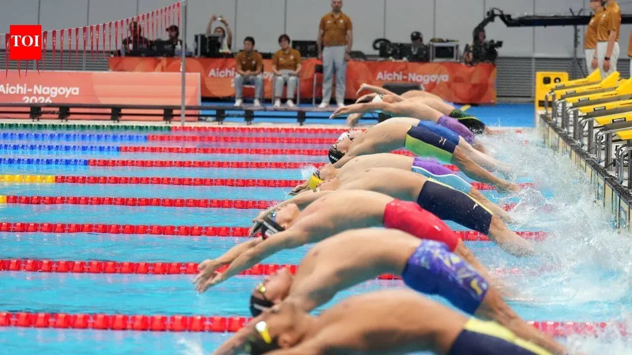 Swimmers diving off blocks in competition
