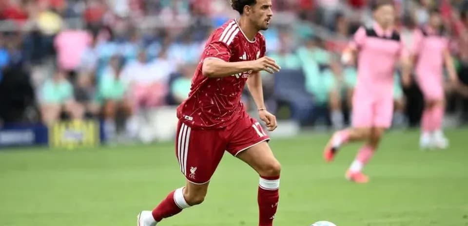 Futbolchi Liverpool formasida to'pni haydashda