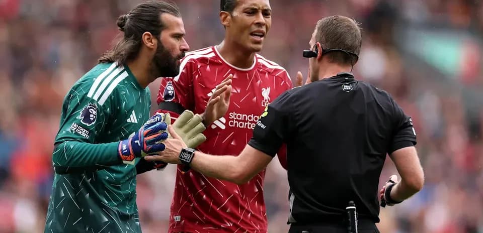Liverpool players arguing with referee during match